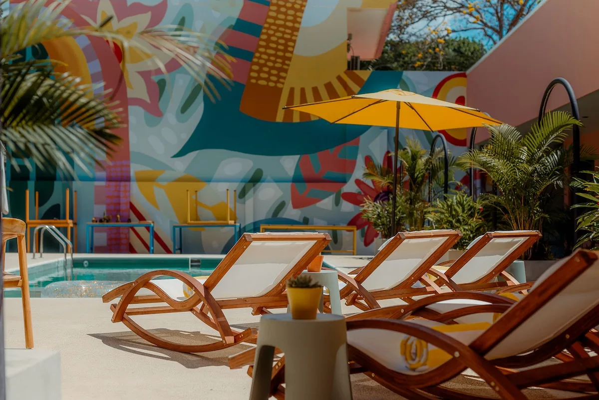Sun loungers by the colorful mural wall beside the Amavi pool