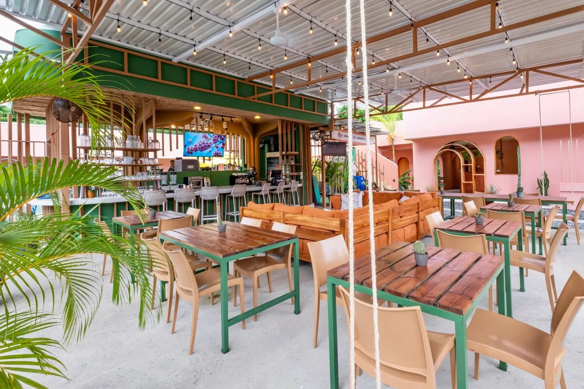Covered outdoor dining area with long wooden tables