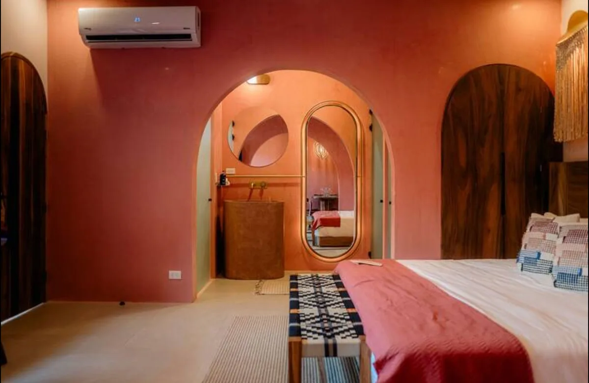 Bedroom with a red runner on the bed and arched dressing nook