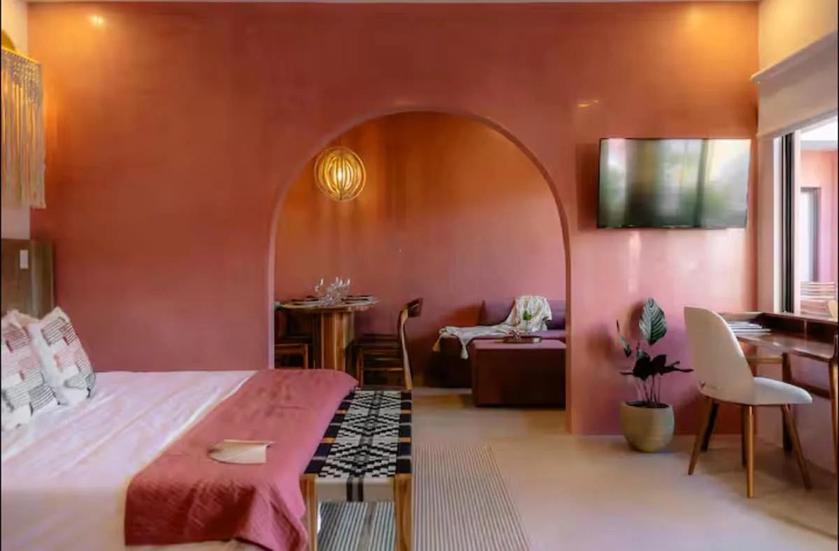 Bedroom with a red bed runner and arched sitting area