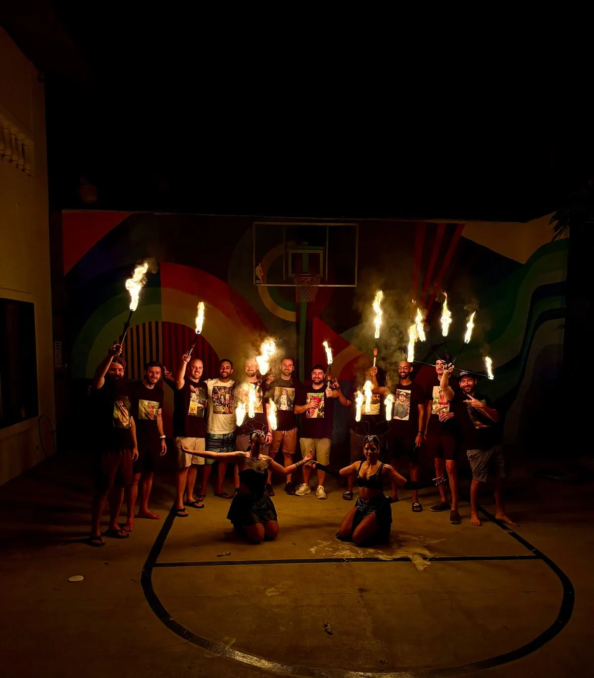 Fire dancers performing on the basketball court at night