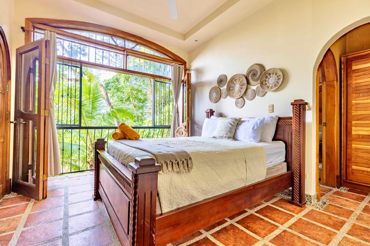 Bedroom with wooden bed and jungle view