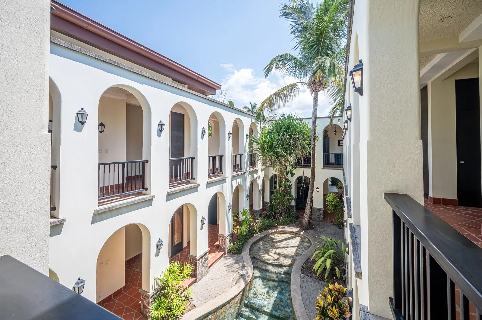 Two storey arched walkway overlooking the courtyard pool